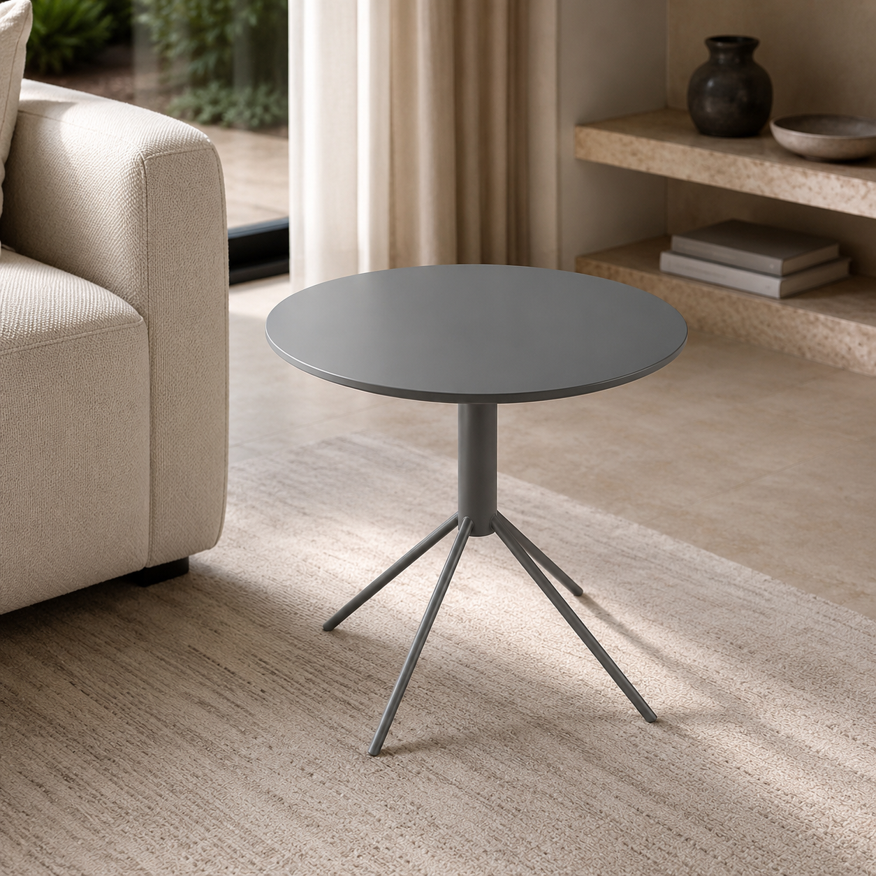 Round gray side table in a living room setting with a beige sofa and curtains.
