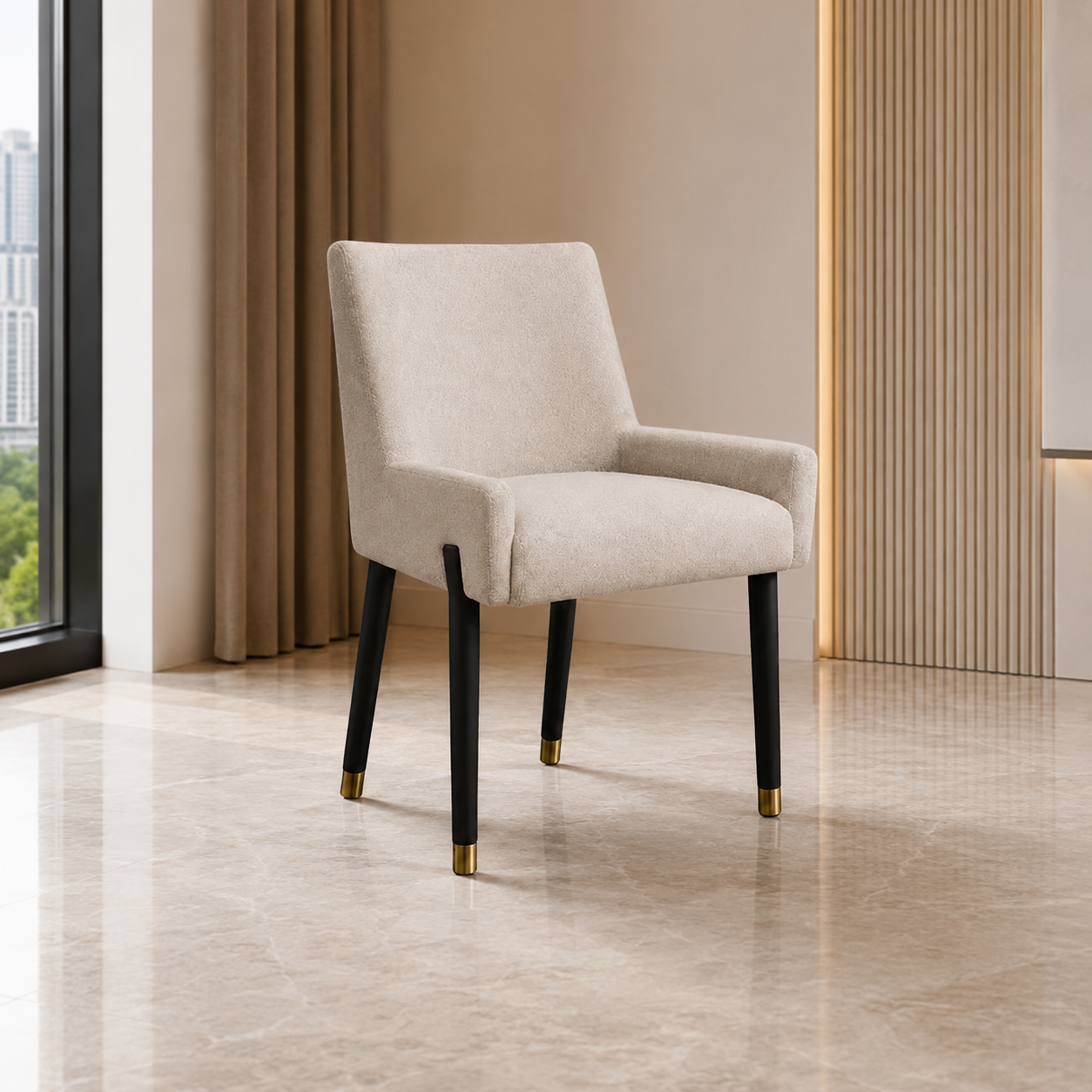 A modern upholstered dining chair with a light beige fabric seat and back, black tapered legs, and gold-toned metal caps, shown in a minimalist interior setting.