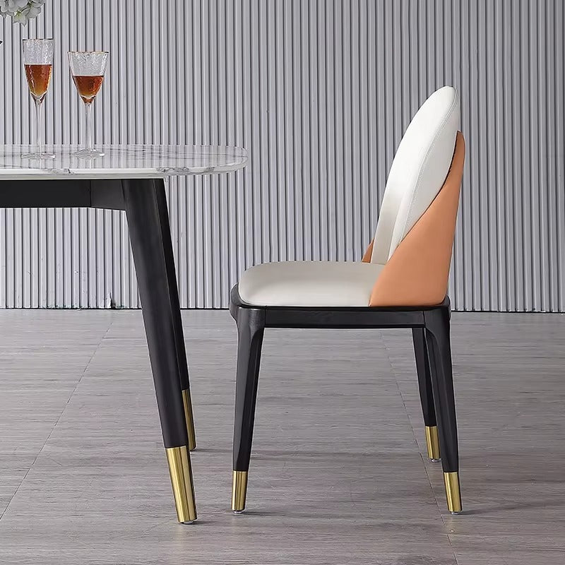 Modern chair with a white and orange backrest and black legs with gold tips in a room with a striped wall.