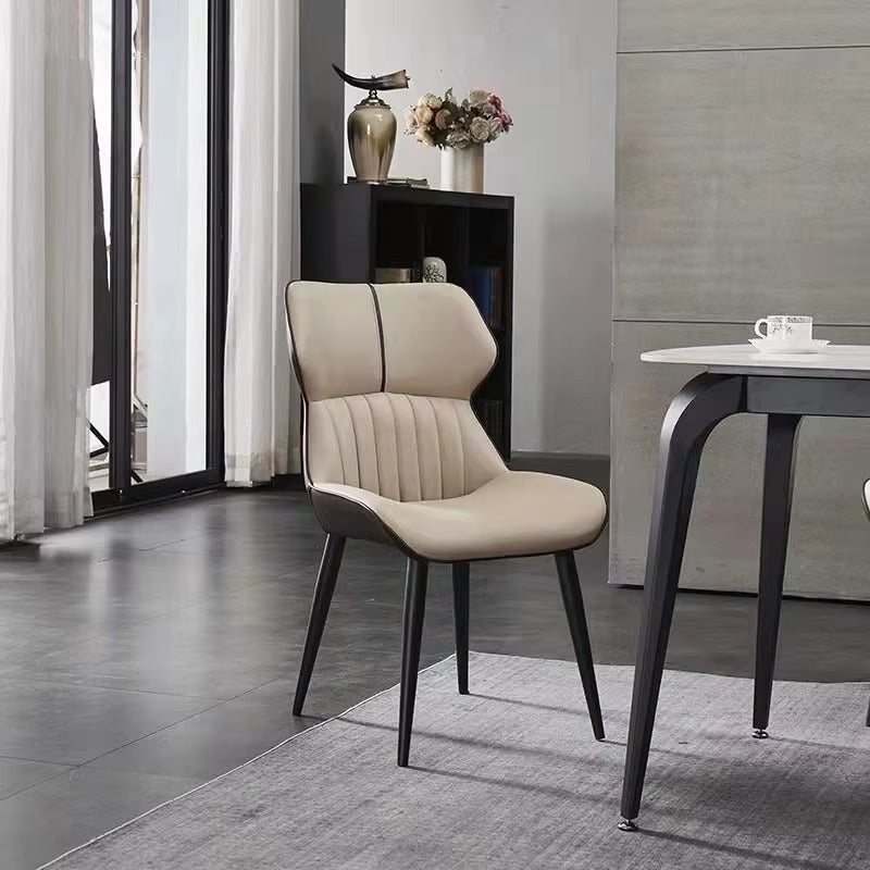 Beige chair in a modern interior setting with a table and decor items.