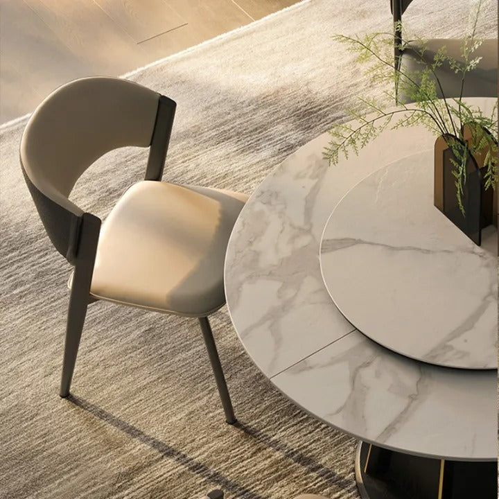 Round marble dining table with a chair in a modern interior setting