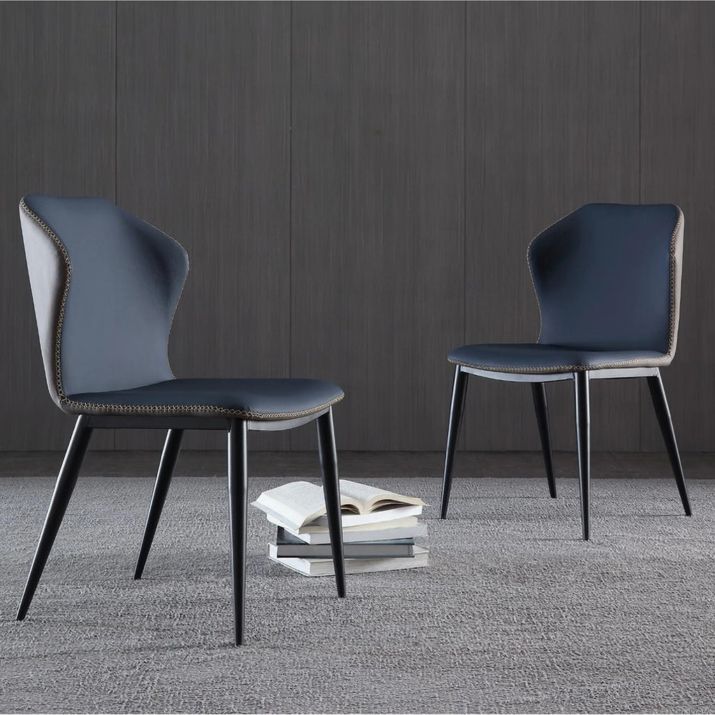 Two blue chairs with black legs on a gray carpeted floor against a dark wooden wall.