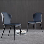 Two blue chairs with black legs on a gray carpeted floor against a dark wooden wall.
