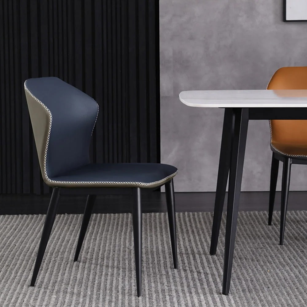 Blue chair with a white table and brown chair in a room with gray walls and carpet.