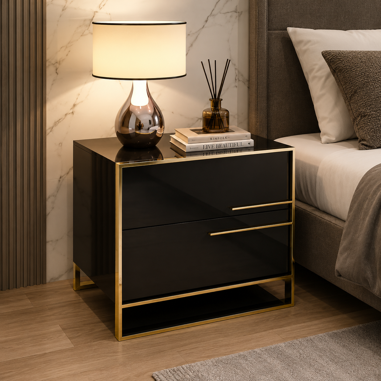 A modern black nightstand with gold trim and legs, styled in a bedroom next to a bed with white linens. The nightstand features a glossy finish, a lower open shelf, and two drawers with slim gold handles.