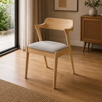 Wooden chair with a gray cushion on a wooden floor in a room with a cabinet and plants.