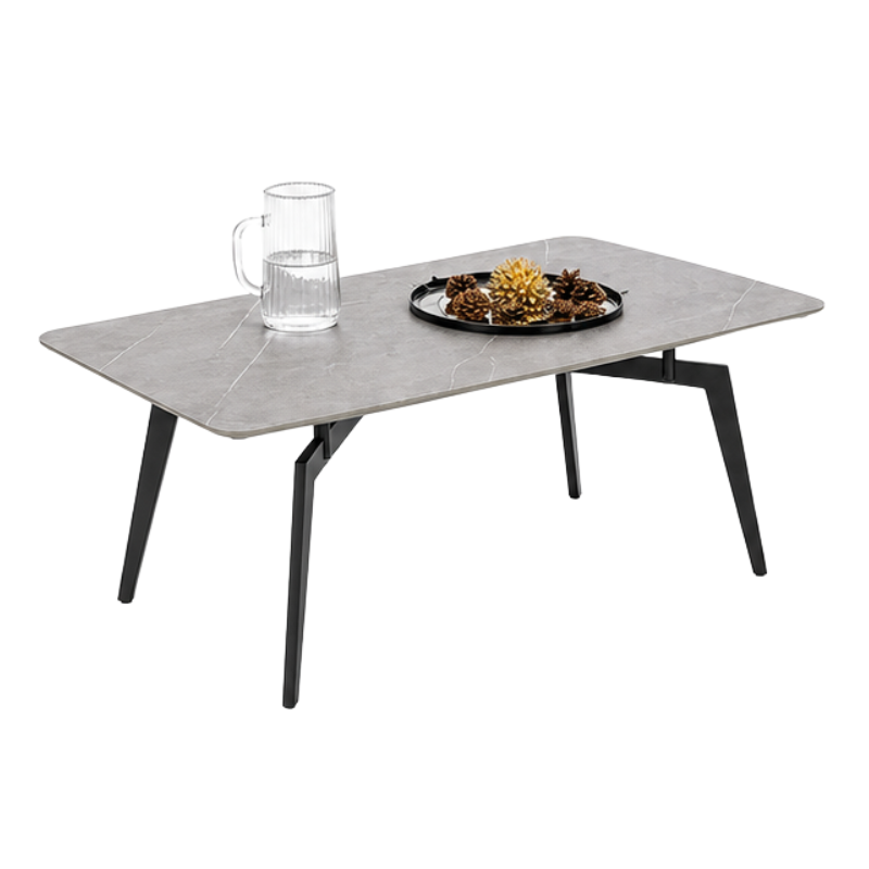 A modern rectangular coffee table with a gray stone-look top and black angled legs, shown on a white background with a glass mug and a decorative tray on top.