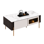 A modern media console table with a white marble-patterned top, dark wood side panels, cream front cabinets, and slim gold legs. A black teapot and cup set are placed on top, shown against a plain white background.