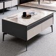 Modern coffee table with marble-like top and dark base in a room setting.