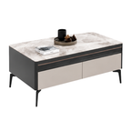 A modern rectangular coffee table with a light gray marble-patterned top, a dark charcoal side panel, and two large beige drawer fronts separated by a thin metallic trim. The table is shown on a plain white background with decorative objects on top.