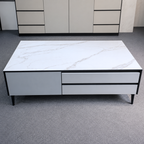 White marble-patterned coffee table with black accents on a gray floor.