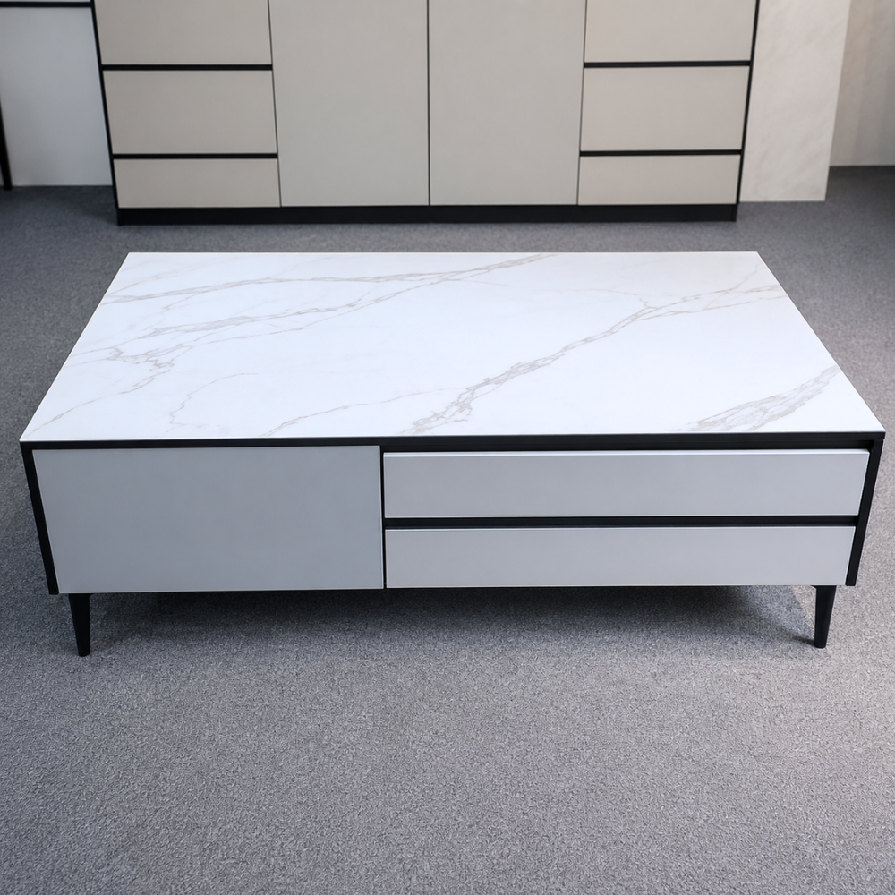 White marble-patterned coffee table with black accents on a gray floor.