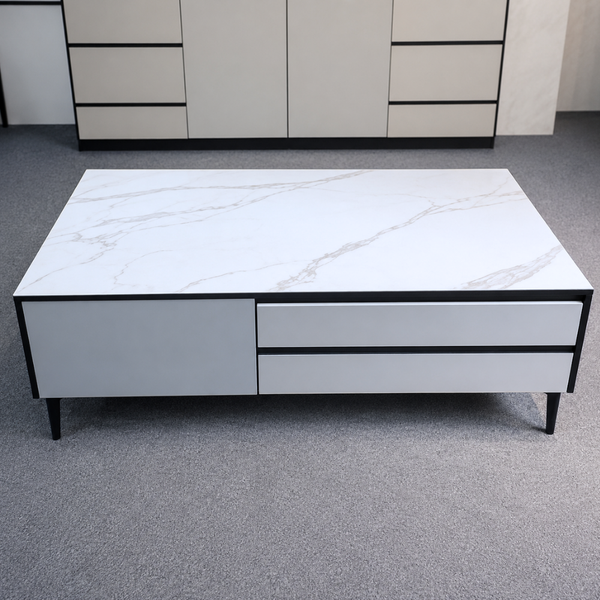 White marble-patterned coffee table with black accents on a gray floor.