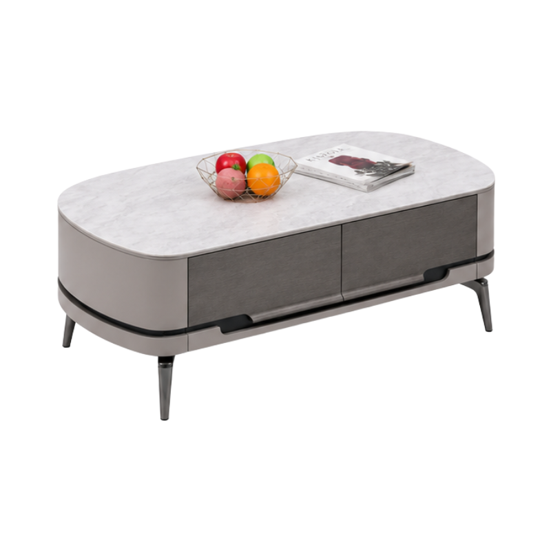 An oval-shaped modern coffee table with a light gray marble-look top, dark gray drawer fronts, slim black legs, and decorative fruit bowl and magazine on top, shown on a plain white background.
