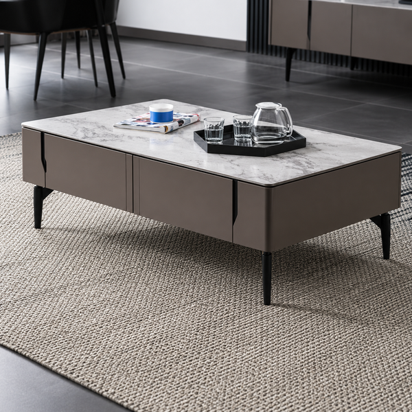 Modern coffee table with a marble top and dark base in a room setting.