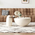 Modern living room with a beige sofa, white coffee table, and decorative items.