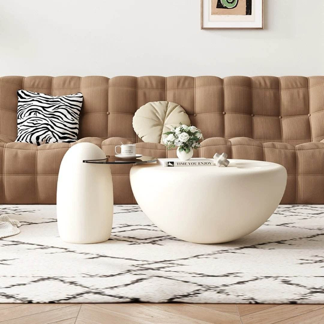 Modern living room with a beige sofa, white coffee table, and decorative items.