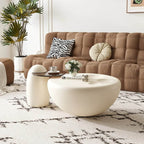 Modern living room with a brown sofa, white coffee table, and decorative items.