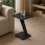 Black side table with a glass of water in a living room setting