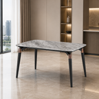 A modern rectangular dining table with a gray marble-patterned top and slim black legs accented by rose gold metal details, set in a contemporary minimalist dining room.