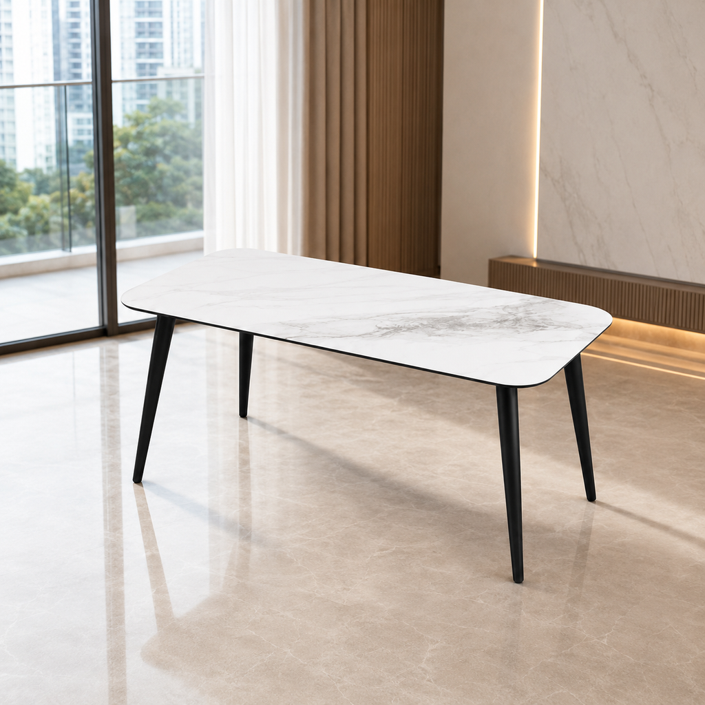 A modern rectangular dining table with a white marble-patterned top and slim black tapered legs, set in a contemporary room with a tiled floor and large windows.
