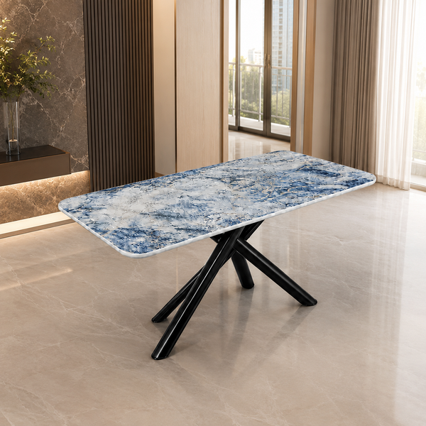 A rectangular dining table with a blue and white marbled stone-look top and black crossed metal legs, shown in a modern interior room with tiled floors and large windows.