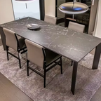 Dining table with marble-like surface and chairs in a room setting