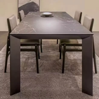 Dining table with marble-like surface and four chairs in a room.