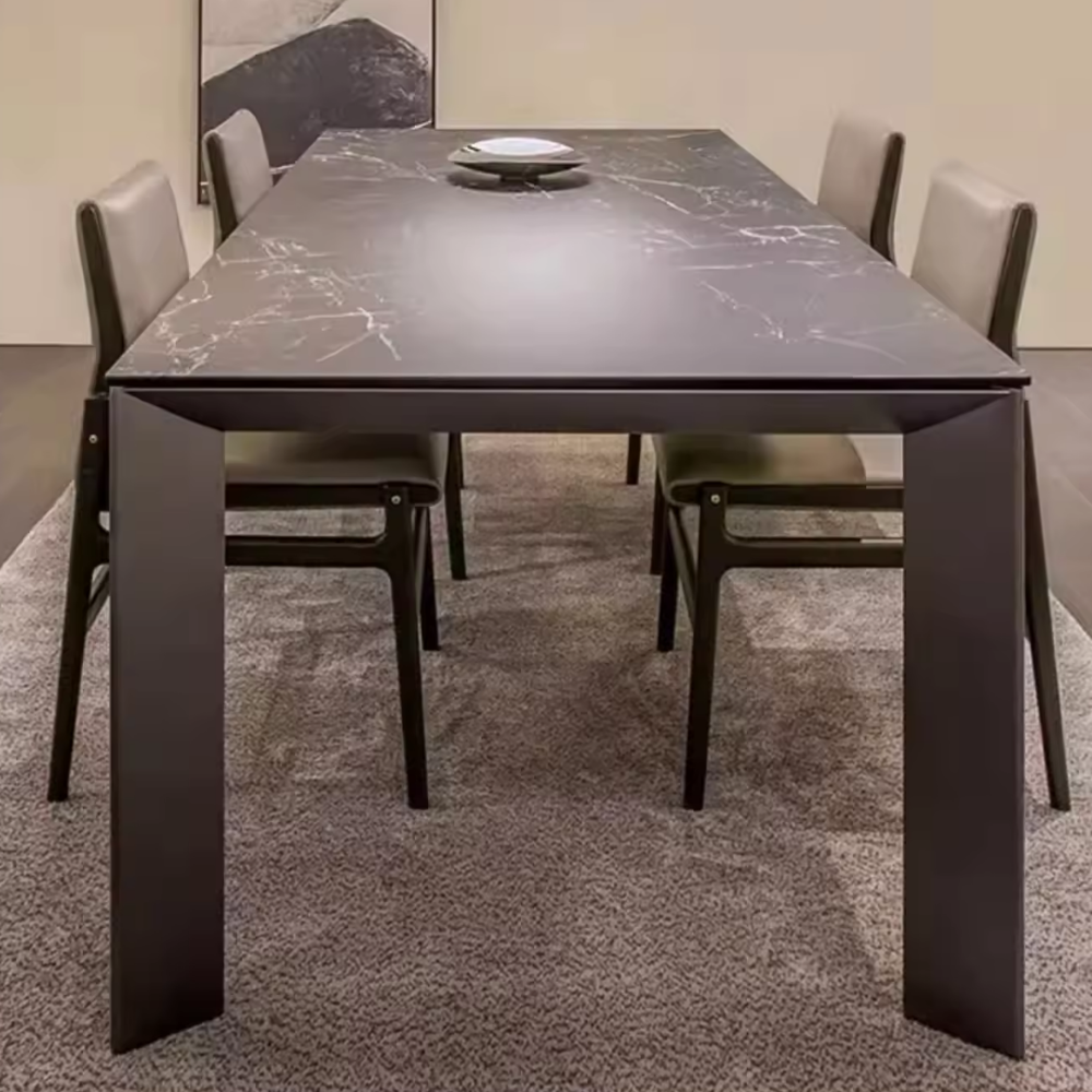 Dining table with marble-like surface and four chairs in a room.