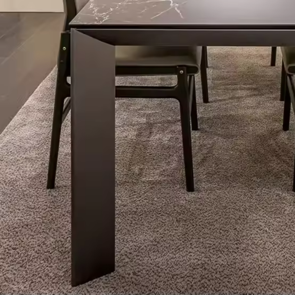 Close-up of a modern dining table leg on a textured floor
