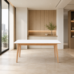 A modern dining table with a white rectangular top and light natural wood legs, positioned in a minimalist, contemporary dining room with beige stone flooring and light wood cabinetry in the background.